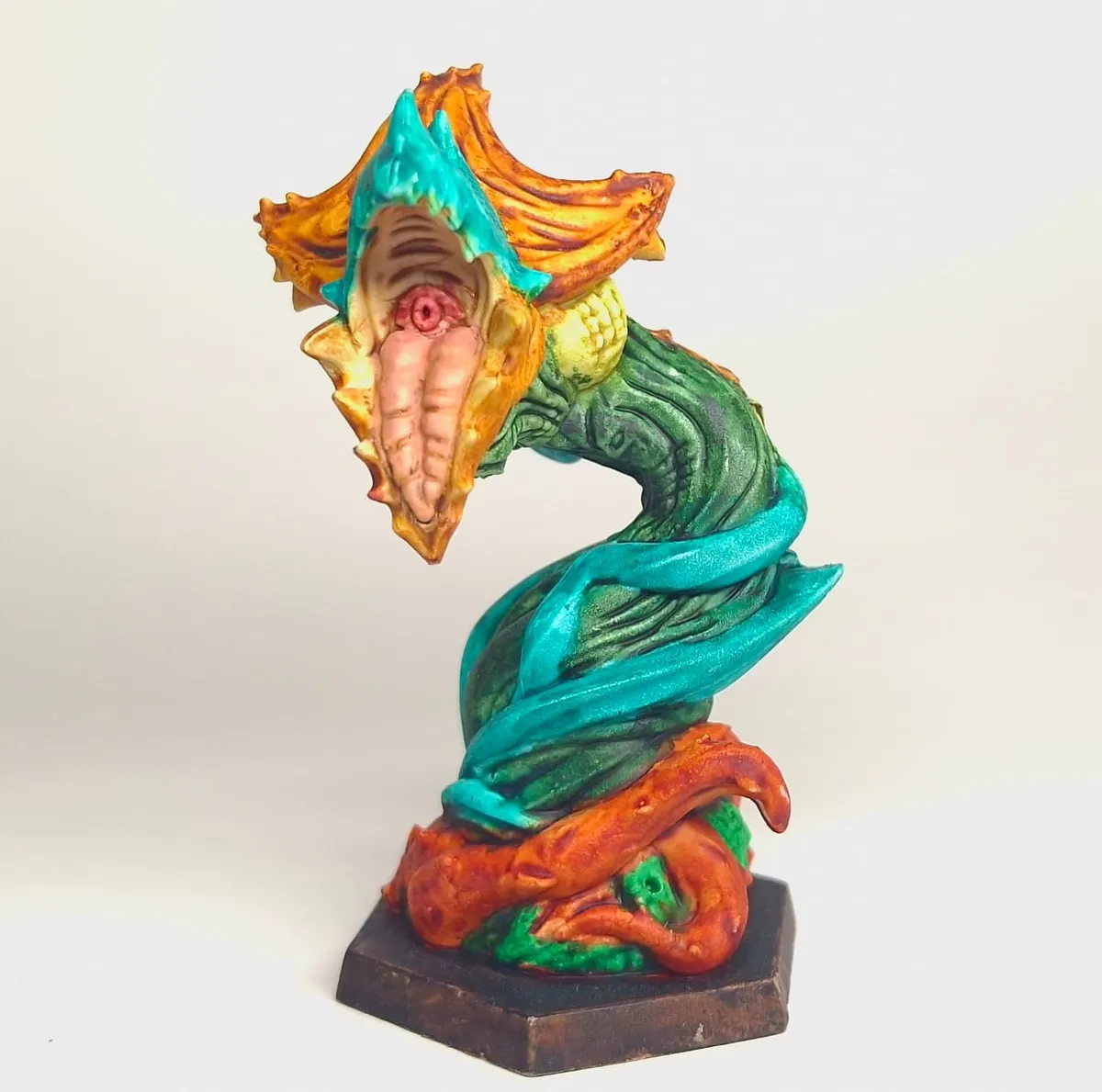 Painted tentacled creature miniature in vivid orange, teal and green