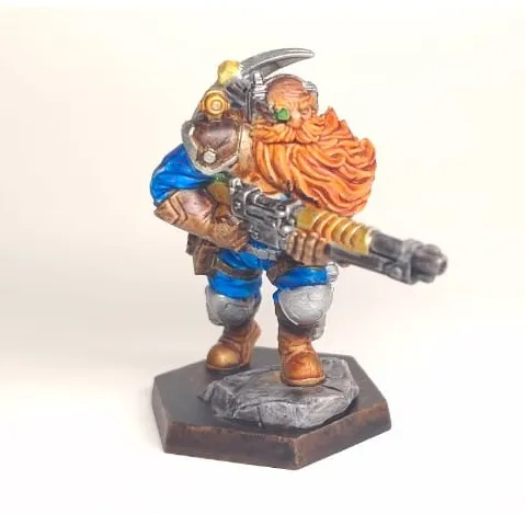 Painted dwarf miniature with a rotary cannon and a braided orange beard